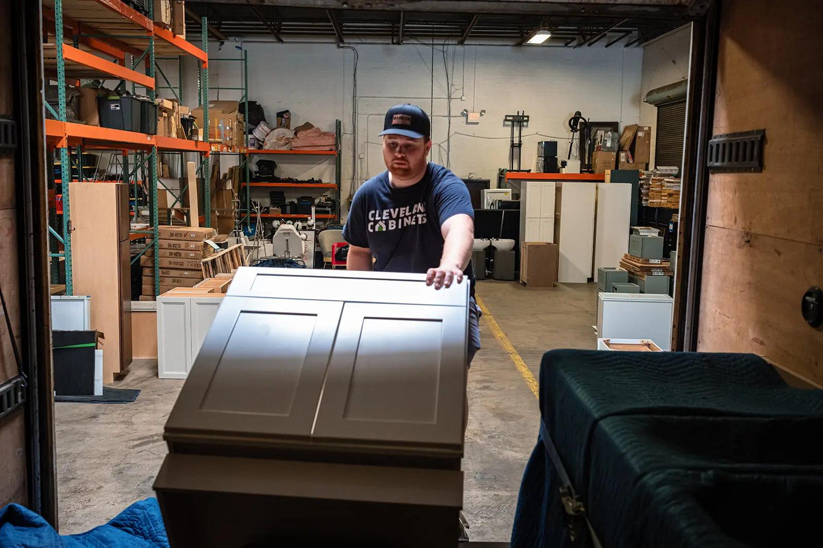 Cabinet warehouse worker moving boxed kitchen cabinets for a Grafton Ohio order