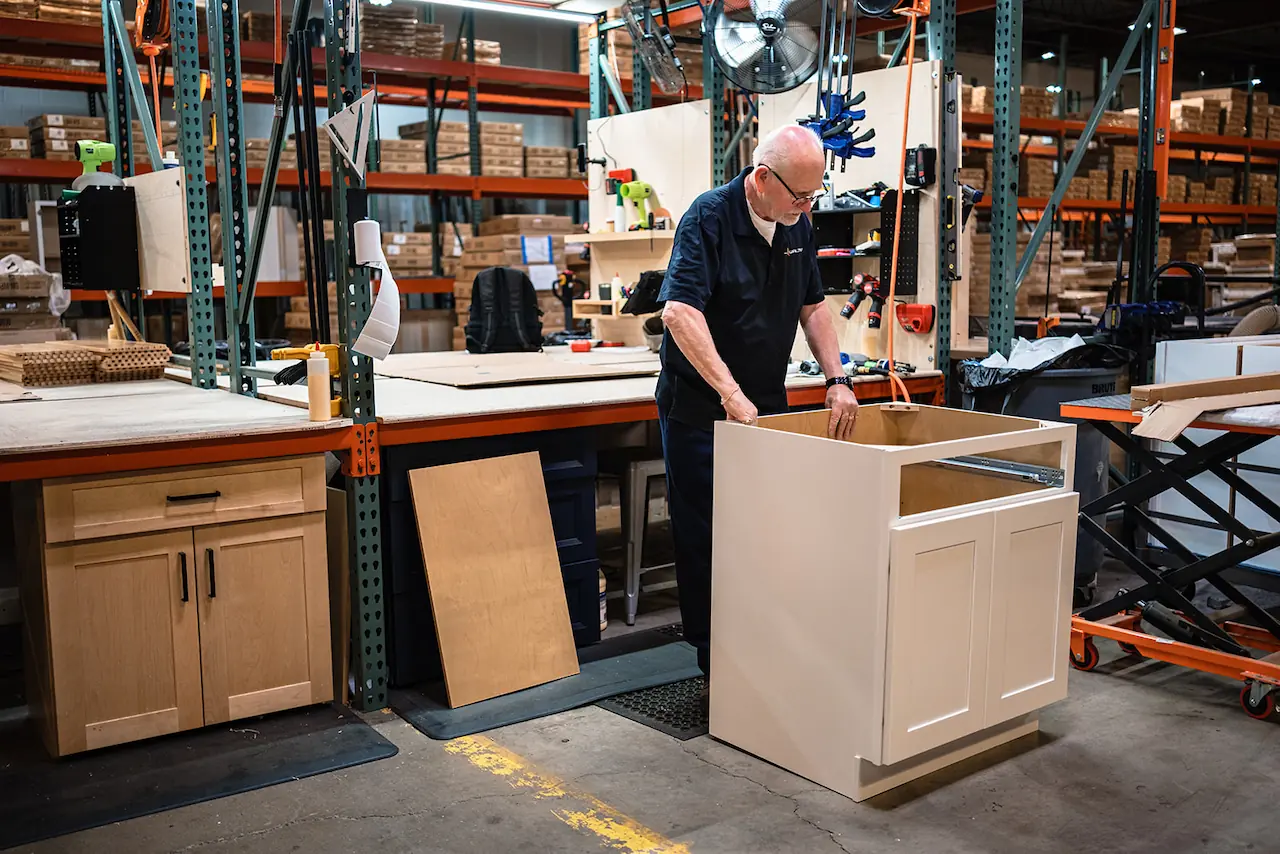 Craftsman assembling a cabinet base for a Medina, Ohio order
