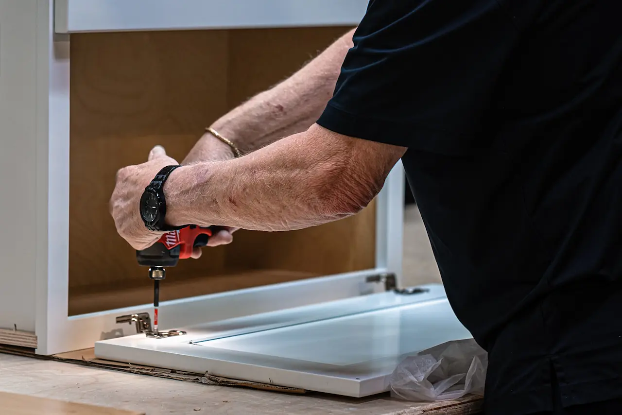 Craftsman using a drill on a cabinet in Bedford Ohio