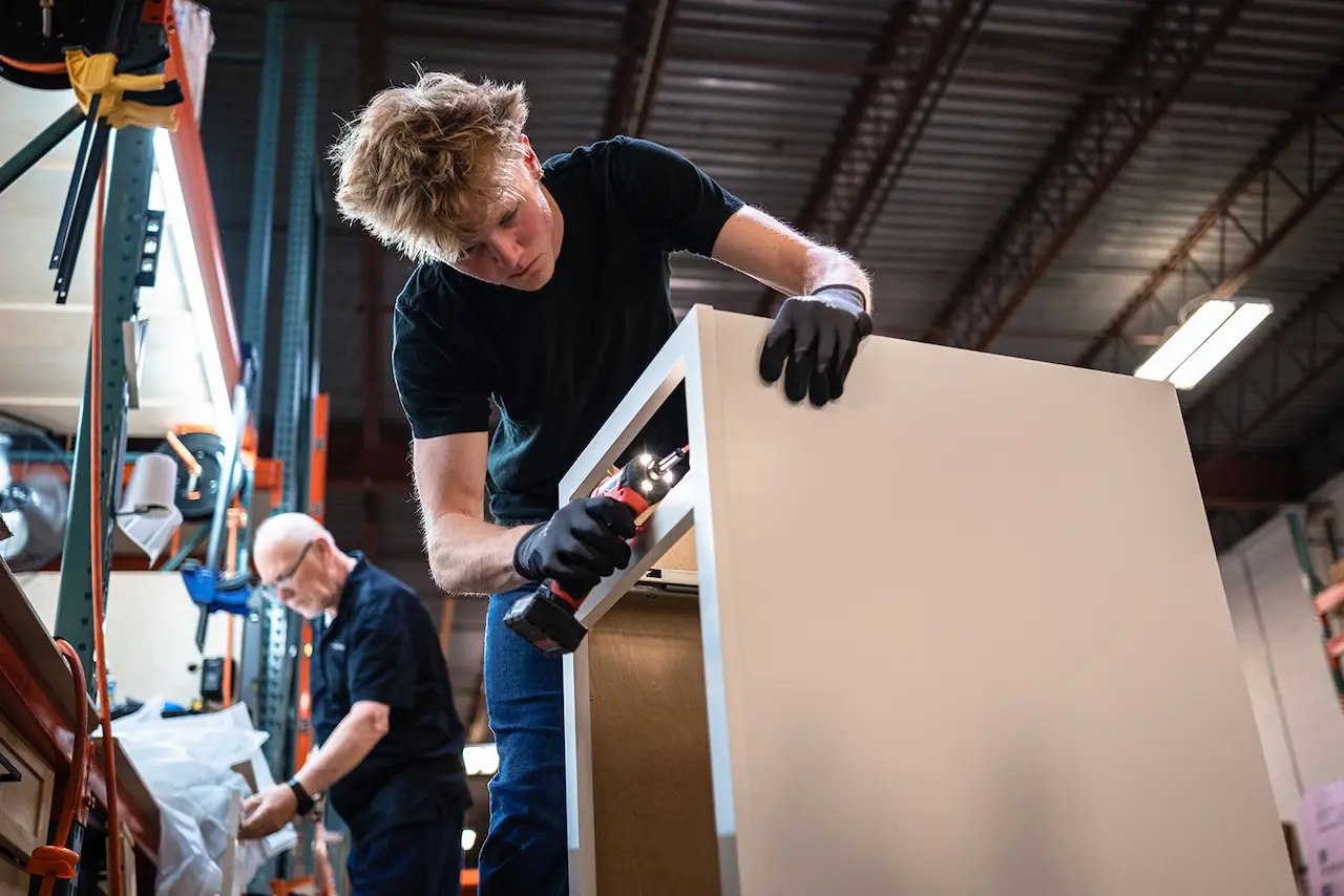 Workers assembling a large cabinet at the Cleveland warehouse for Brecksville Ohio