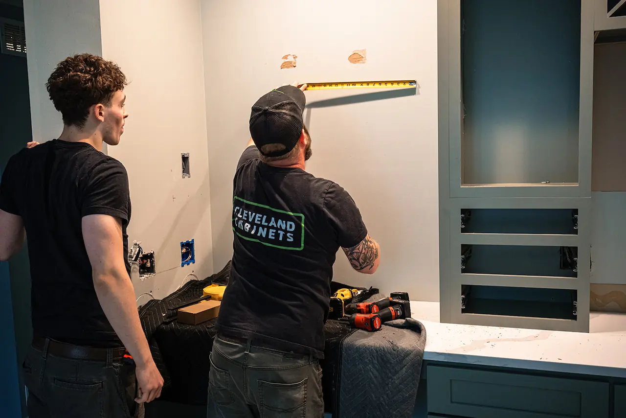 Installers fitting new kitchen cabinets in a Barberton, Ohio kitchen