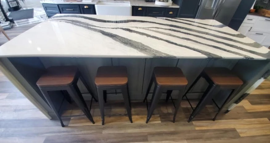 Dark gray Shaker cabinets on the showroom island with a black and white waterfall countertop, Cleveland