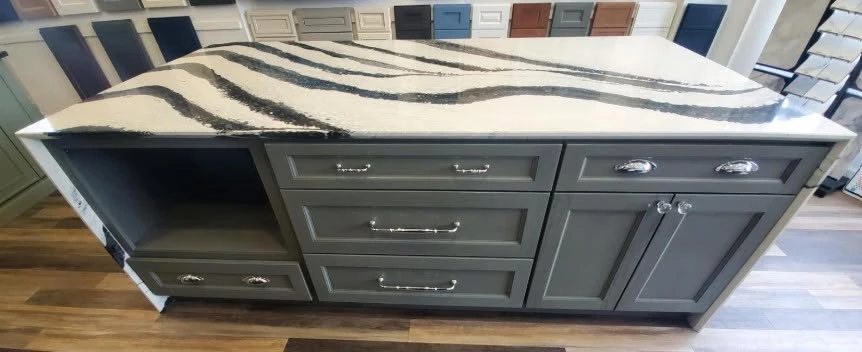 Charcoal gray showroom island with storage drawers and a bold veined countertop, Cleveland, Ohio
