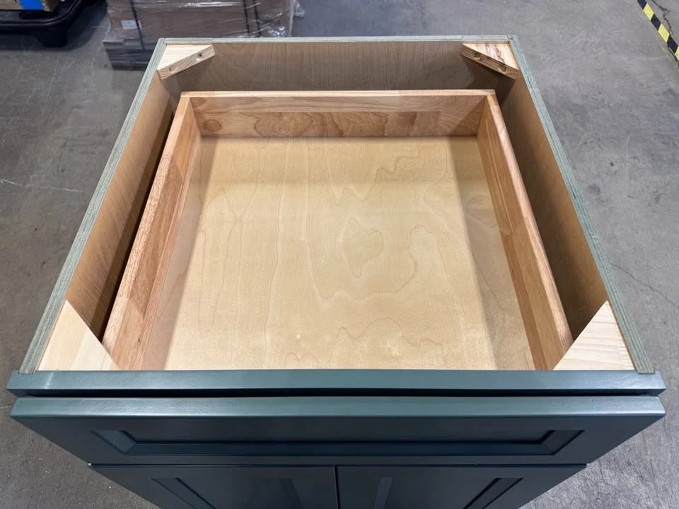 Green kitchen cabinet with the dovetail drawer box pulled open, Cleveland warehouse