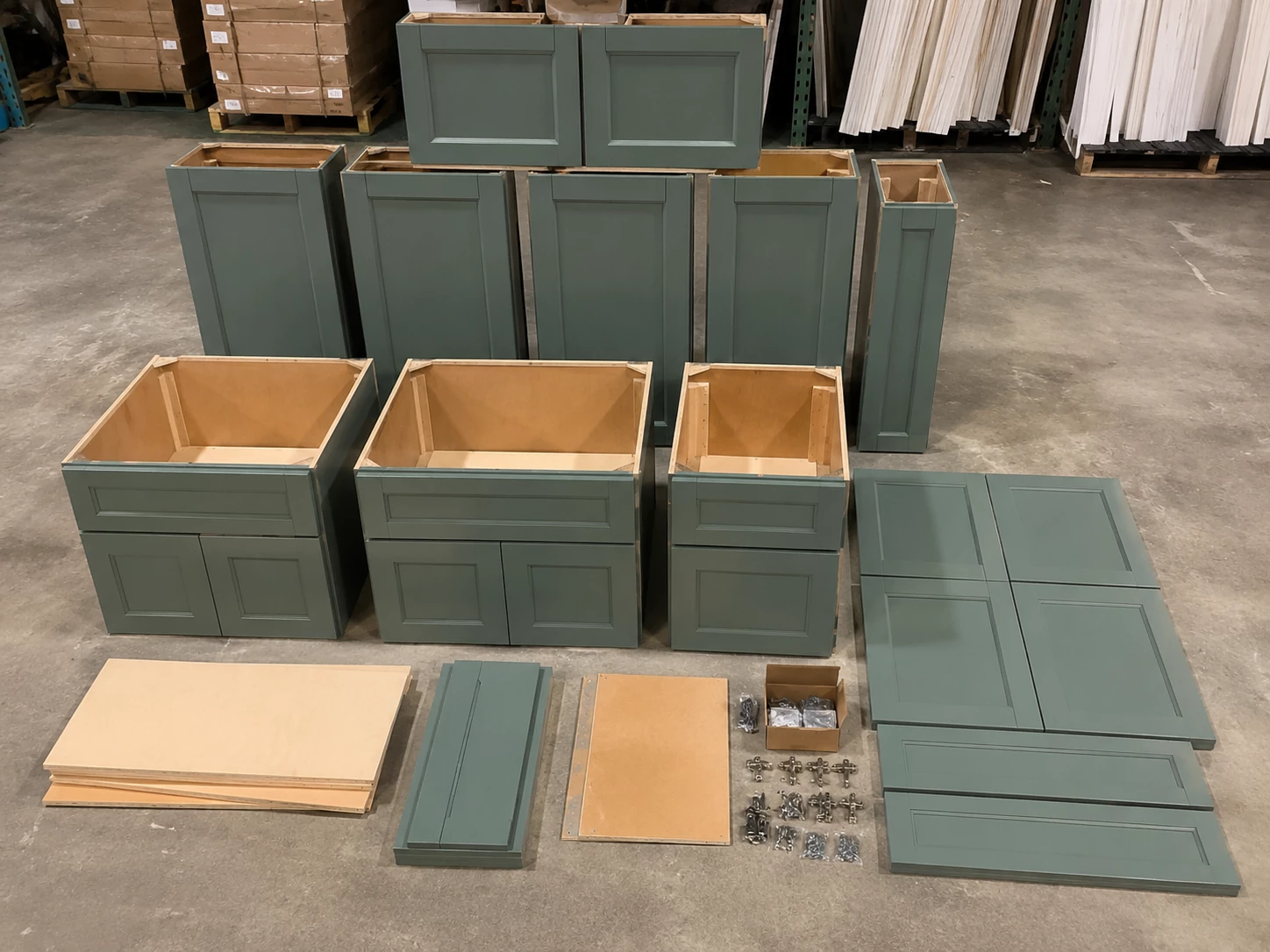 Unassembled sage green RTA cabinet panels and hardware at the Cleveland warehouse